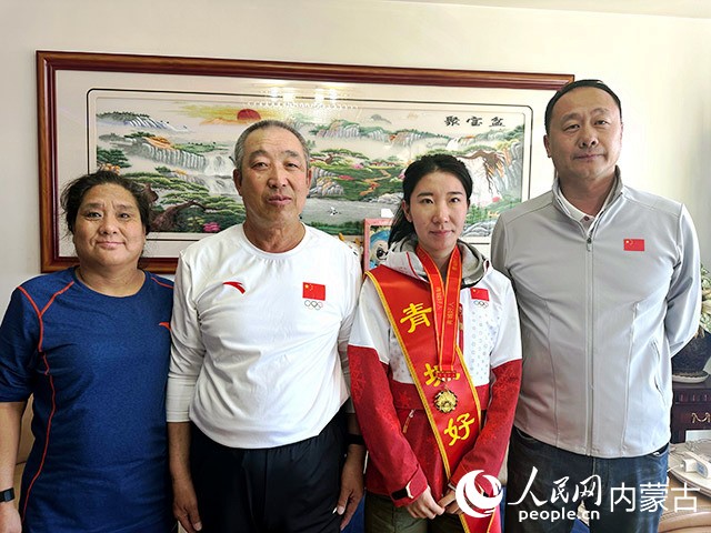 韩梅与父（左二）母（左一）和教练王宇鹏合影。实习生 刘瀛摄