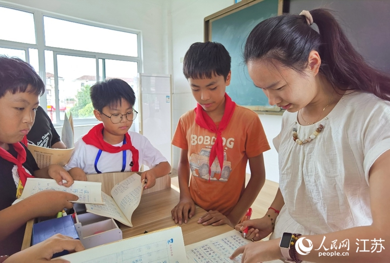 语文老师徐婕下课后给学生们辅导作业。人民网记者 王继亮摄